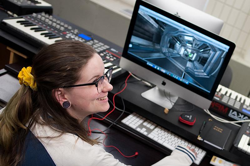 一个学生在电脑上使用音乐程序的图像.